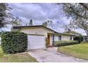 Inviting home with a clean, manicured lawn and a convenient attached garage at 1216 Lotus Path, Clearwater, FL 33756