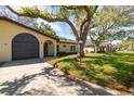 Well-maintained single-story home with an attached garage and mature trees in a residential neighborhood at 12200 Vonn Rd # 6D, Largo, FL 33774