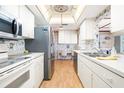 Well-lit kitchen featuring stainless steel appliances, ample cabinet space, and light wood floors at 12200 Vonn Rd # 6D, Largo, FL 33774
