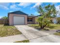 Cozy home features a one-car garage and a simple, well-maintained front yard at 12704 128Th Ln, Largo, FL 33774