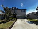 Charming two-story home with landscaped front yard and attached two-car garage at 14618 Scottburgh Glen Dr, Wimauma, FL 33598