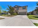Inviting two-story home showcasing a well-manicured front yard and a spacious driveway at 14618 Scottburgh Glen Dr, Wimauma, FL 33598