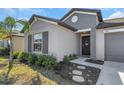 Inviting home exterior with a neat lawn, dark shutters and door, and well-placed landscaping at 15613 Charr Island St, Sun City Center, FL 33573