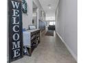 Inviting entryway with neutral tones, tile flooring, and stylish bench and welcome sign at 15613 Charr Island St, Sun City Center, FL 33573