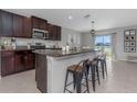 Stylish kitchen featuring granite countertops, stainless steel appliances, and barstool seating at 15613 Charr Island St, Sun City Center, FL 33573