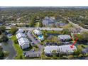 Aerial view of a condo community with a pool, ponds, landscaping, parking, and nearby commercial and residential areas at 2087 Hunters Glen Dr # 126, Dunedin, FL 34698