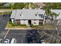 Aerial view of condo building and grounds featuring parking and landscaping, with the building's roof and chimneys visible at 2087 Hunters Glen Dr # 126, Dunedin, FL 34698