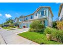 Charming townhome exterior with manicured lawns, beautiful landscaping, and attached garages on a bright, sunny day at 2270 Spring Lake Ct, Clearwater, FL 33763
