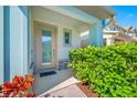 Inviting front door with glass accents, complemented by decorative plants and landscaping, set against a light-colored facade at 2270 Spring Lake Ct, Clearwater, FL 33763