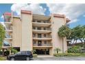 Multi-story condo with balconies, covered parking, and mature palms in lush landscaping at 2700 Bayshore Blvd # 9404, Dunedin, FL 34698