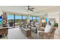 Bright living room with plush seating, ceiling fan, and balcony with scenic views at 2700 Bayshore Blvd # 9404, Dunedin, FL 34698