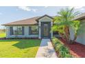 Welcoming front entrance featuring a screened entry and decorative landscaping at 27941 Austin Woods Dr, Dade City, FL 33525