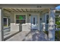 Close-up of the home's front entrance featuring a tiled patio, storm door, and painted stucco facade at 3218 N 16Th St, Tampa, FL 33605