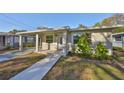 Inviting front exterior showcasing a covered carport, tiled entry, and freshly painted stucco at 3218 N 16Th St, Tampa, FL 33605
