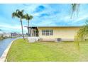 Spacious backyard with lush grass, mature palm trees, and waterfront canal access at 35246 Tiffani Ct, Zephyrhills, FL 33541
