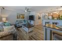 Comfortable living room, featuring a sofa set, TV, and breakfast bar with stools at 4103 Gulf Blvd # 205, St Pete Beach, FL 33706