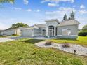 Beautiful single-story home with a grey exterior, landscaped yard, and attached two-car garage at 4320 Northampton Dr, New Port Richey, FL 34653