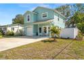 Beautiful turquoise house with a manicured lawn and covered front porch area at 5148 Newton S Ave, Gulfport, FL 33707