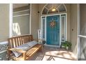 Inviting front porch with bench seating, decorative wreath, and a blue front door at 5225 Eagle Blvd, Land O Lakes, FL 34639