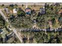 An aerial shot showcases the property's boundaries, surrounded by lush trees and neighboring homes in a serene setting at 8539 Orbit Ave, New Port Richey, FL 34654