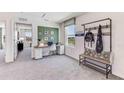 Bright, carpeted office with a large window, desk, and a modern coat rack with bench at 10590 Dusty Boot Rd, Land O Lakes, FL 34638