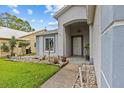Inviting front entrance with an arched porch and tiled walkway through the garden at 1489 Ridge Shore Dr, Tarpon Springs, FL 34689