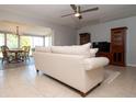 Spacious living room with a comfortable sofa, ceiling fan, and adjacent dining area at 1503 Council Dr, Sun City Center, FL 33573