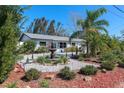 Charming single-story home featuring a decorative fountain and lush landscaping in the front yard at 201 79Th Ne Ave, St Petersburg, FL 33702