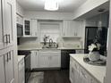Modern kitchen featuring white cabinetry, stainless steel appliances, stylish countertops and dark wood flooring at 2710 W Osborne Ave # 1, Tampa, FL 33614
