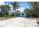 Charming single-story home with mature trees and a concrete driveway at 300 Westwinds Dr, Palm Harbor, FL 34683