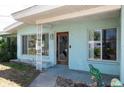 Charming front porch with decorative wood door and mature plantings at 300 Westwinds Dr, Palm Harbor, FL 34683
