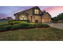 Beautiful home exterior at twilight with stone accents and landscaped front yard at 3303 Ranchdale Dr, Plant City, FL 33566