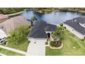 An aerial view shows a home with a three-car garage, a well-manicured lawn, and pond views at 3417 Diamond Falls Cir, Land O Lakes, FL 34638