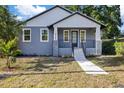 Charming blue two-story home with a welcoming front porch and landscaped front yard at 3902 E Henry Ave, Tampa, FL 33610