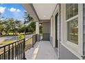 View from the cozy front porch with black iron railings and natural sunlight at 3902 E Henry Ave, Tampa, FL 33610