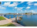 Dock extends into the water, providing a serene and picturesque waterfront living experience under blue sky at 3906 Versailles Dr, Tampa, FL 33634