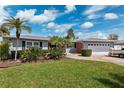 Charming single-story home featuring a well-manicured lawn, lush landscaping, and a convenient two-car garage at 3906 Versailles Dr, Tampa, FL 33634