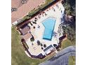 Aerial view of a community pool area with lounge chairs and ample space for relaxation at 411 Bloom Ct # 2A, Sun City Center, FL 33573
