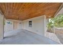 Attached covered parking with concrete floor and ceiling, additional storage, and view to the front yard at 434 Pevetty Dr, Plant City, FL 33563