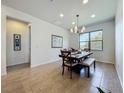 Open dining area with tile flooring, a modern chandelier, and a large window with lots of natural light at 5016 Bella Armonia Cir, Wimauma, FL 33598