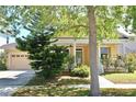 Inviting front exterior of a yellow home featuring a well-manicured lawn and charming curb appeal at 5709 Sea Turtle Pl, Apollo Beach, FL 33572