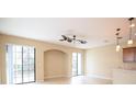 An open-concept living room featuring tile floors, an arched entryway and two sliding glass doors for natural light at 5710 Kingletsound Pl, Lithia, FL 33547