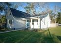 Well-maintained white exterior and a manicured lawn with blue front door at 6401 N 47Th St, Tampa, FL 33610