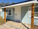 Close-up of the front porch with new tile and wood columns, showcasing the home's address at 6708 S Faul St, Tampa, FL 33616