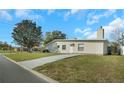 Side view of a home with a long driveway and a well-manicured lawn on a sunny day at 6901 298Th N Ave, Clearwater, FL 33761