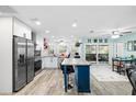 Bright, open kitchen with stainless steel appliances, a blue island, and a breakfast nook with access to screened-in patio at 7208 Baltusrol Dr, New Port Richey, FL 34654