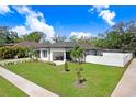 Aerial view of a modern white home with a well-maintained lawn and a white fence surrounding the backyard at 7403 Edgemere Rd, Tampa, FL 33625