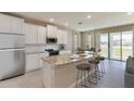 Bright kitchen with stainless steel appliances, granite counters and a large island with stool seating at 7795 Wheat Stone Dr, Zephyrhills, FL 33540