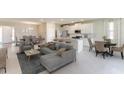 Open-concept living room with modern furnishings, a dining area, and an island kitchen at 7795 Wheat Stone Dr, Zephyrhills, FL 33540