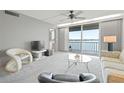Bright living room with floor-to-ceiling windows providing water views and access to the balcony at 7910 Sun Island S Dr # 302, South Pasadena, FL 33707